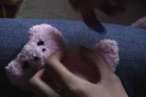 Stitching the head and body of pink plushies